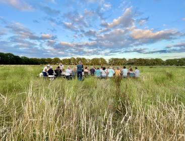 mensen aan tafel midden in een weiland